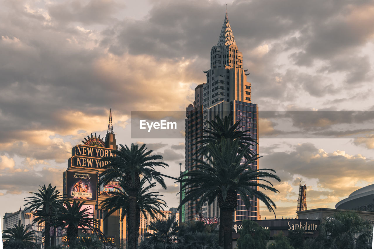 LOW ANGLE VIEW OF BUILDING AGAINST CLOUDY SKY DURING SUNSET