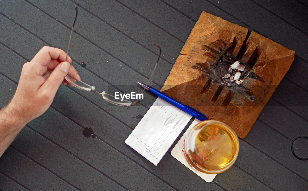 HIGH ANGLE VIEW OF MAN DRINKING GLASS WITH TABLE