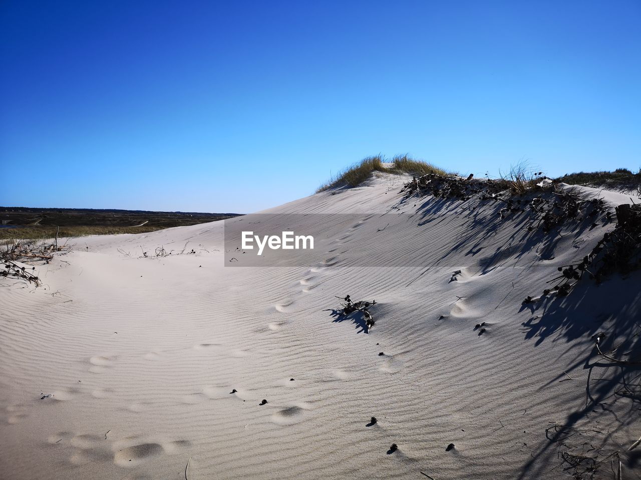 Scenic view of desert against clear blue sky