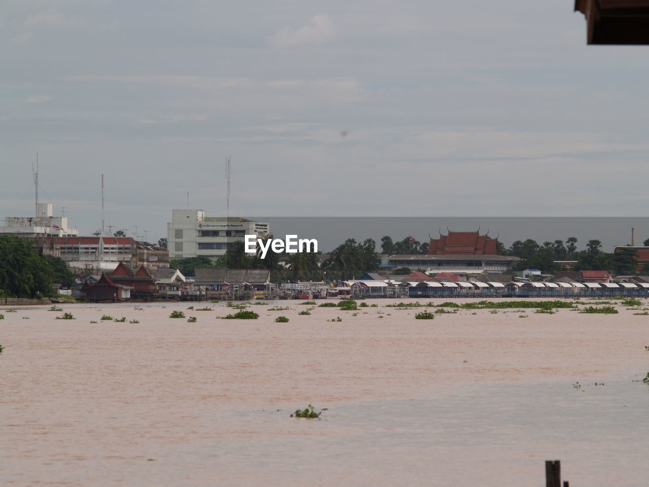 SCENIC VIEW OF RIVER AMIDST BUILDINGS AGAINST SKY