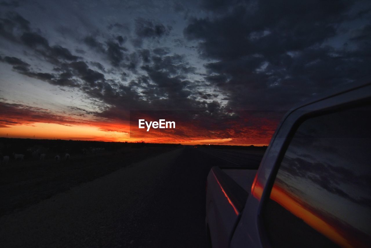 Car on road against sky at sunset