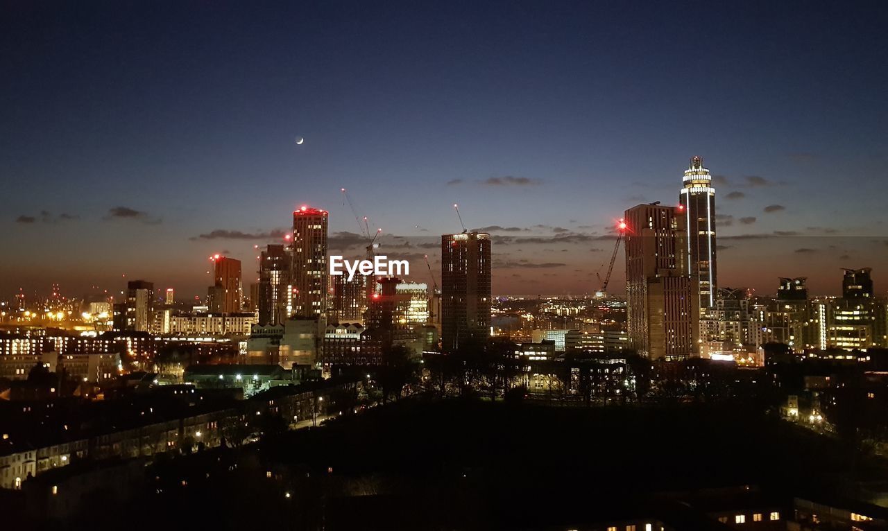 ILLUMINATED CITYSCAPE AGAINST SKY