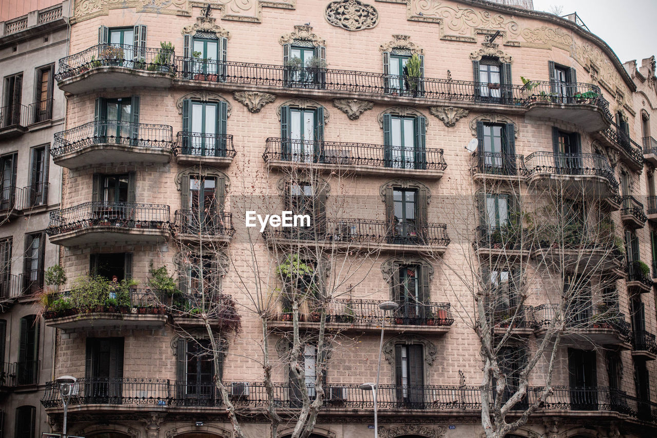 LOW ANGLE VIEW OF APARTMENT BUILDING WITH BALCONY