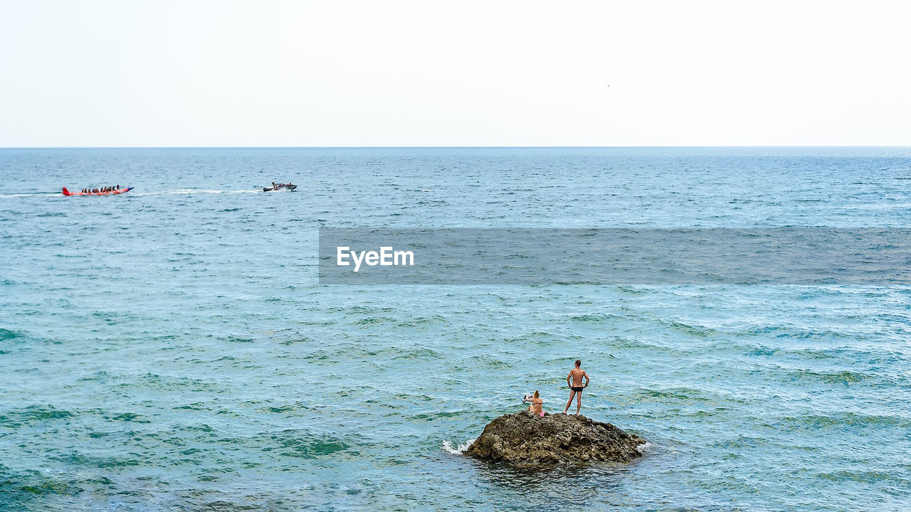 VIEW OF ROCK IN SEA AGAINST CLEAR SKY