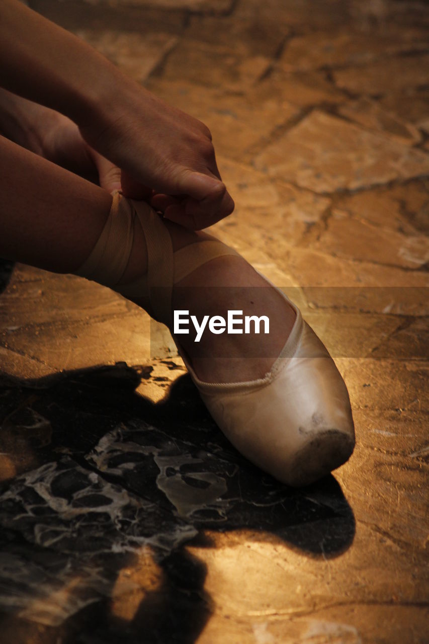 Close-up of a woman tying ballet shoe