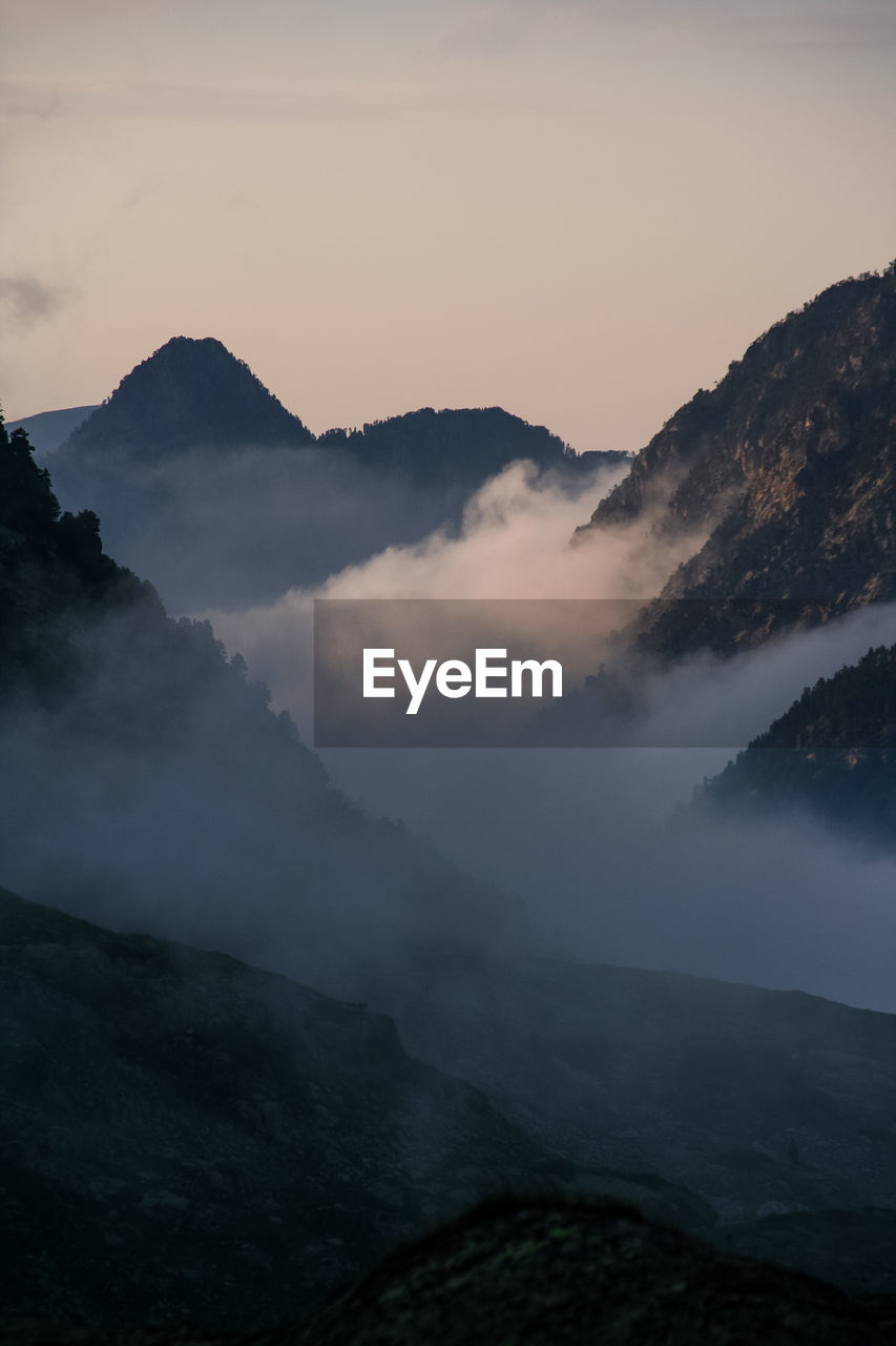 Scenic view of pyrenees against sky during foggy weather