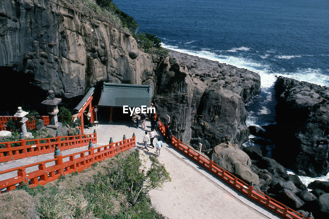People entering shrine against the sea