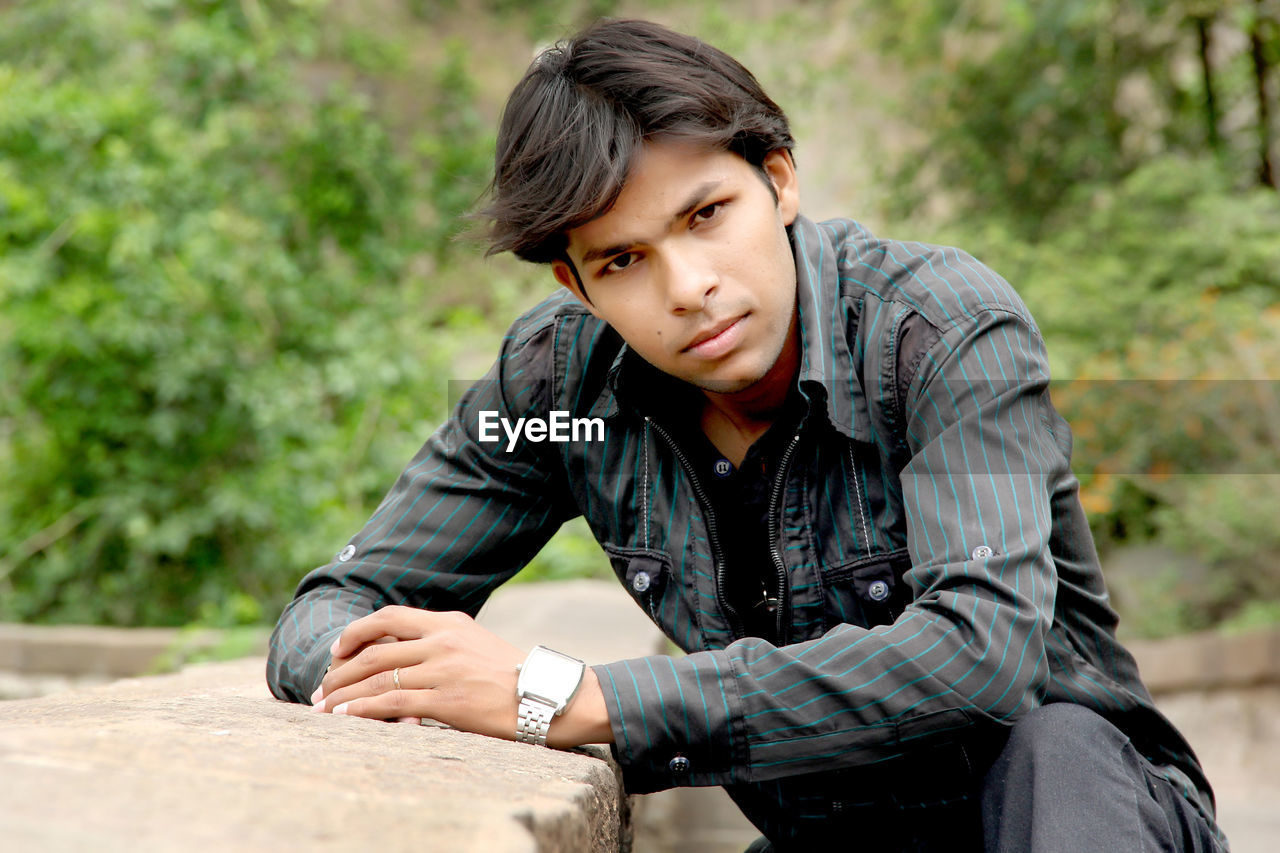 Portrait of young man sitting outdoors