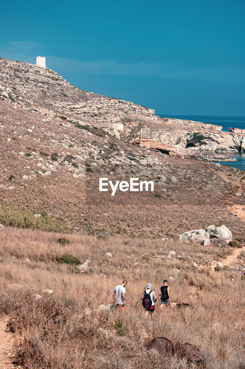 PEOPLE WALKING ON MOUNTAIN ROAD