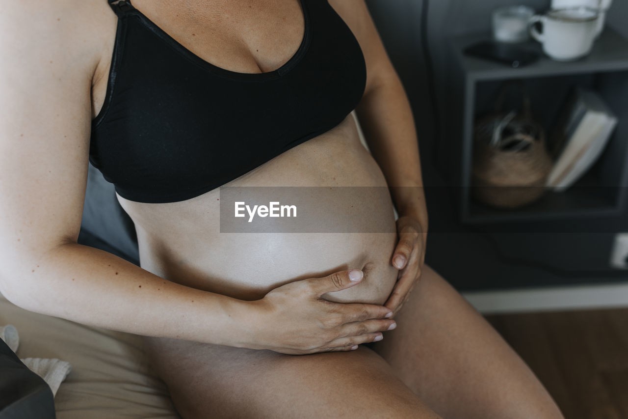 Close-up of pregnant woman touching belly