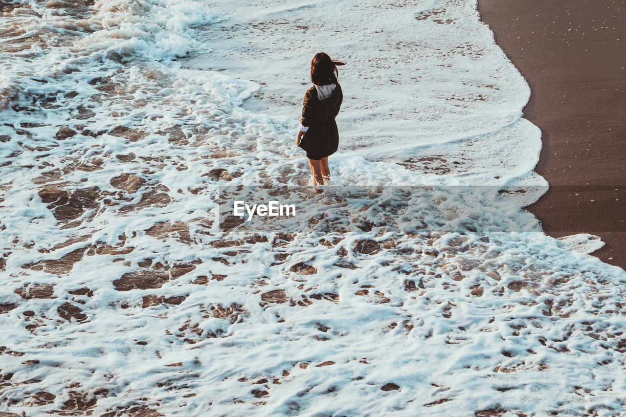 Female standing in waves on a beach in santa monica california. 