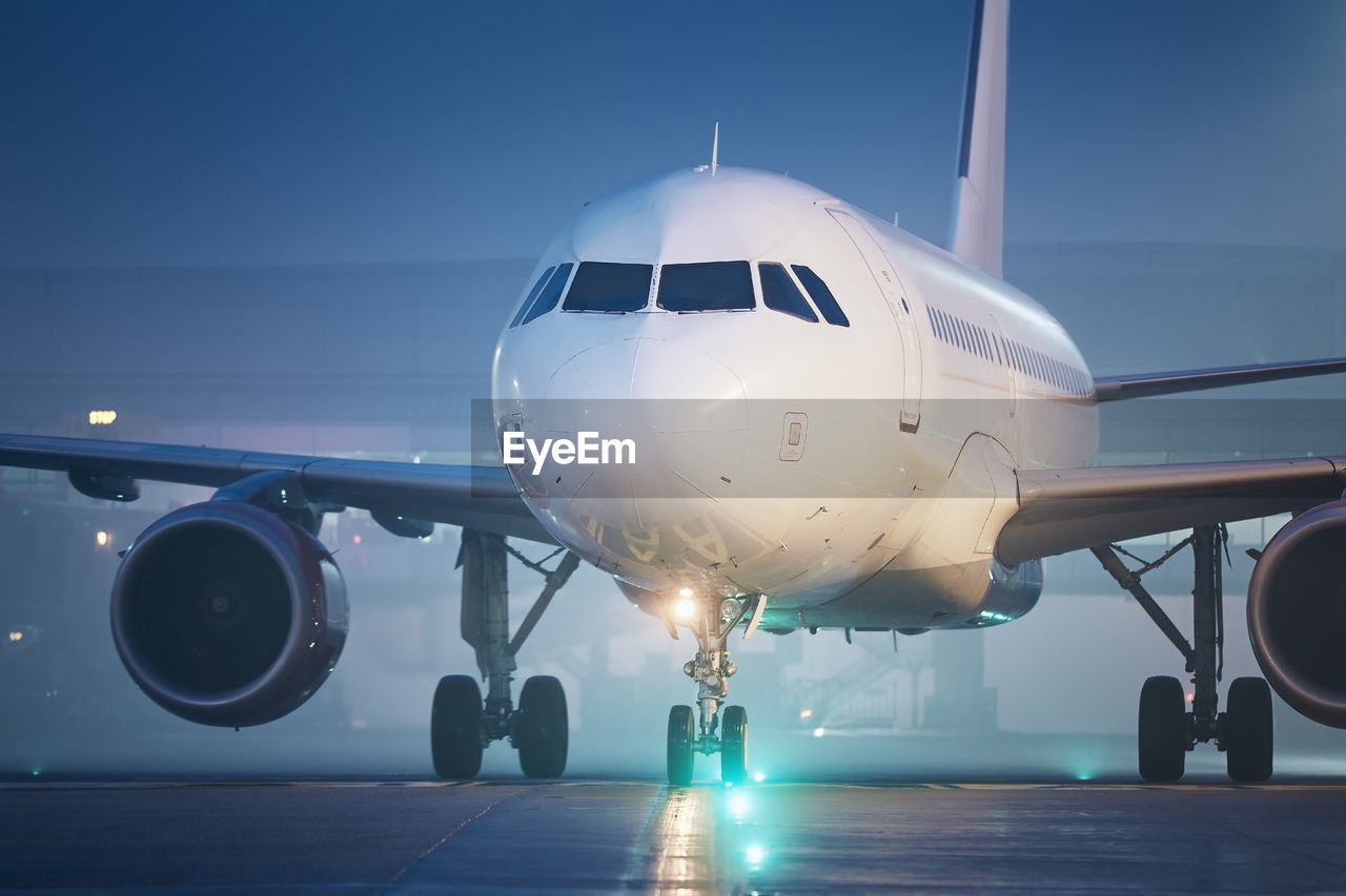 Front view of airplane at airport at night. plane during taxiing to runway for take off.