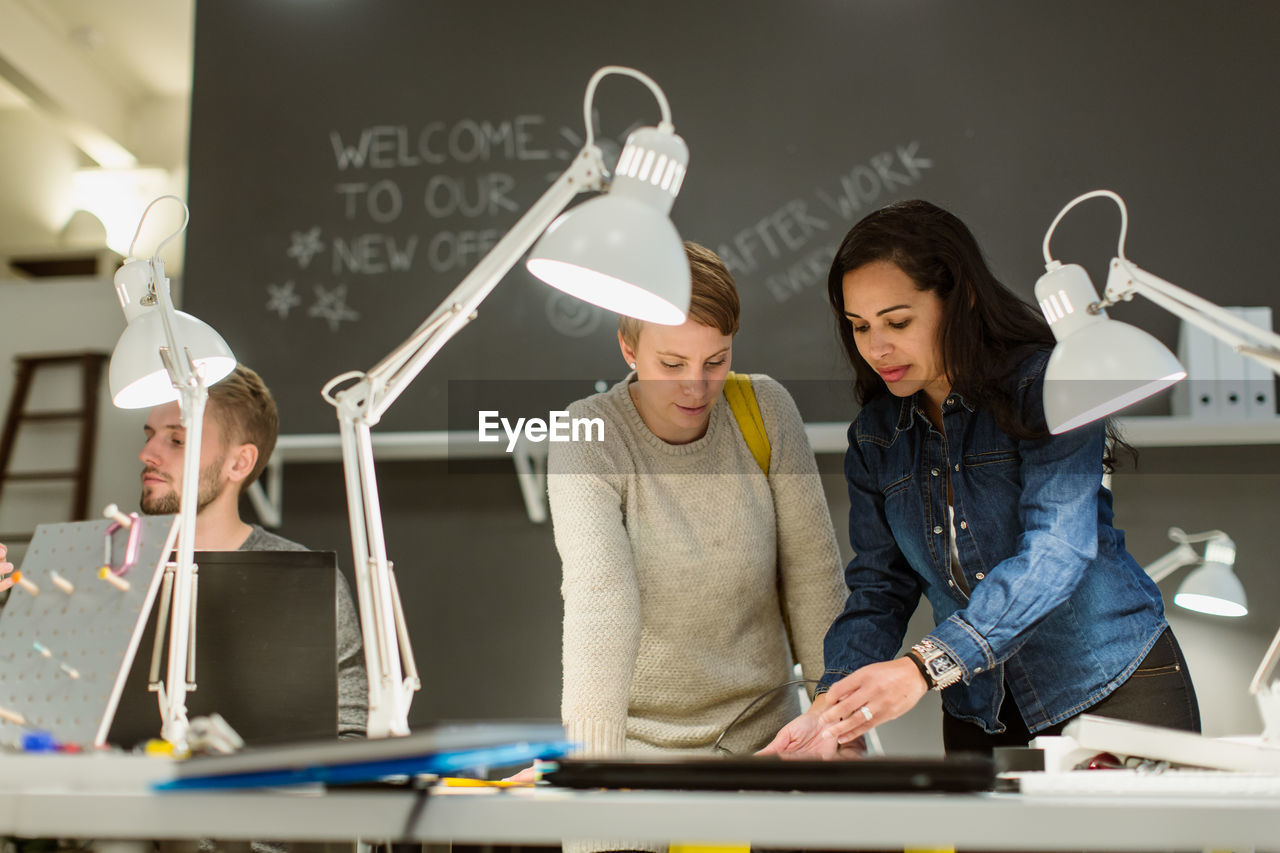 Confident multi-ethnic colleagues working at desk in creative office