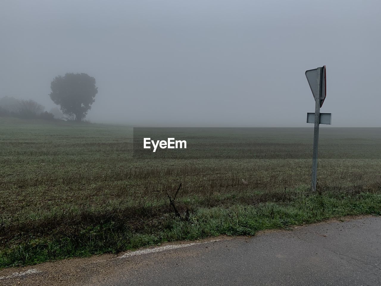 ROAD BY FIELD AGAINST SKY