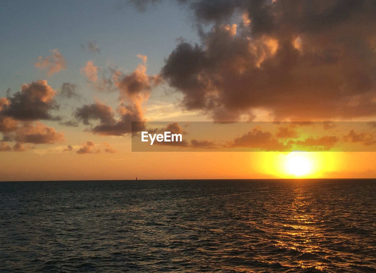 SCENIC VIEW OF SEA AGAINST ORANGE SKY DURING SUNSET