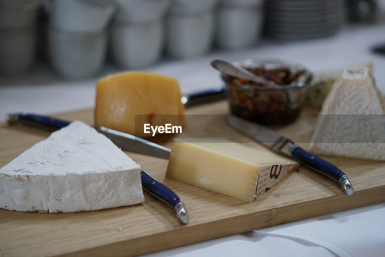 CLOSE-UP OF FOOD ON CUTTING BOARD AT TABLE