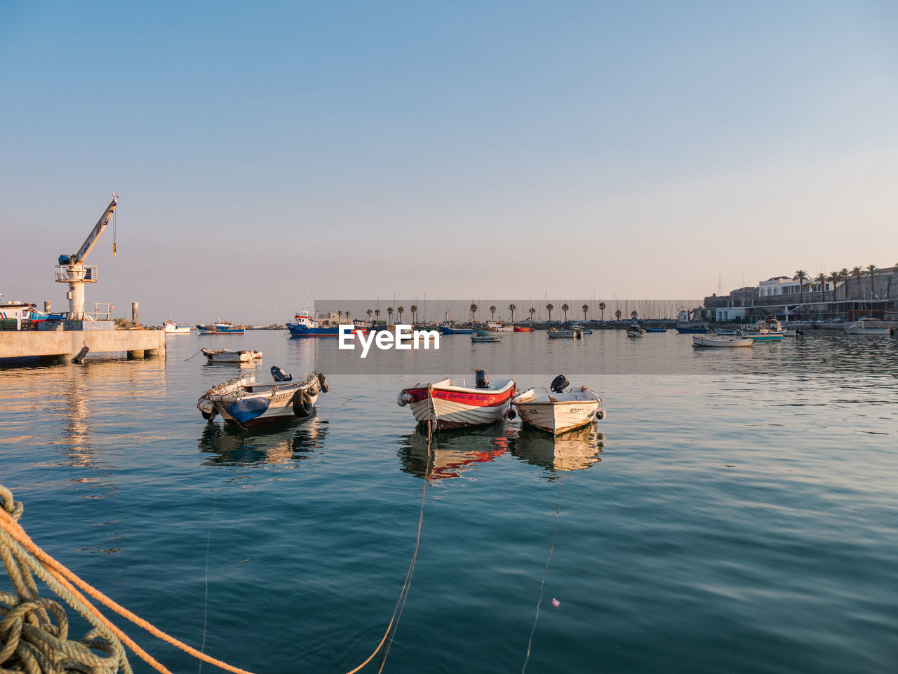 Boats moored in sea against clear sky