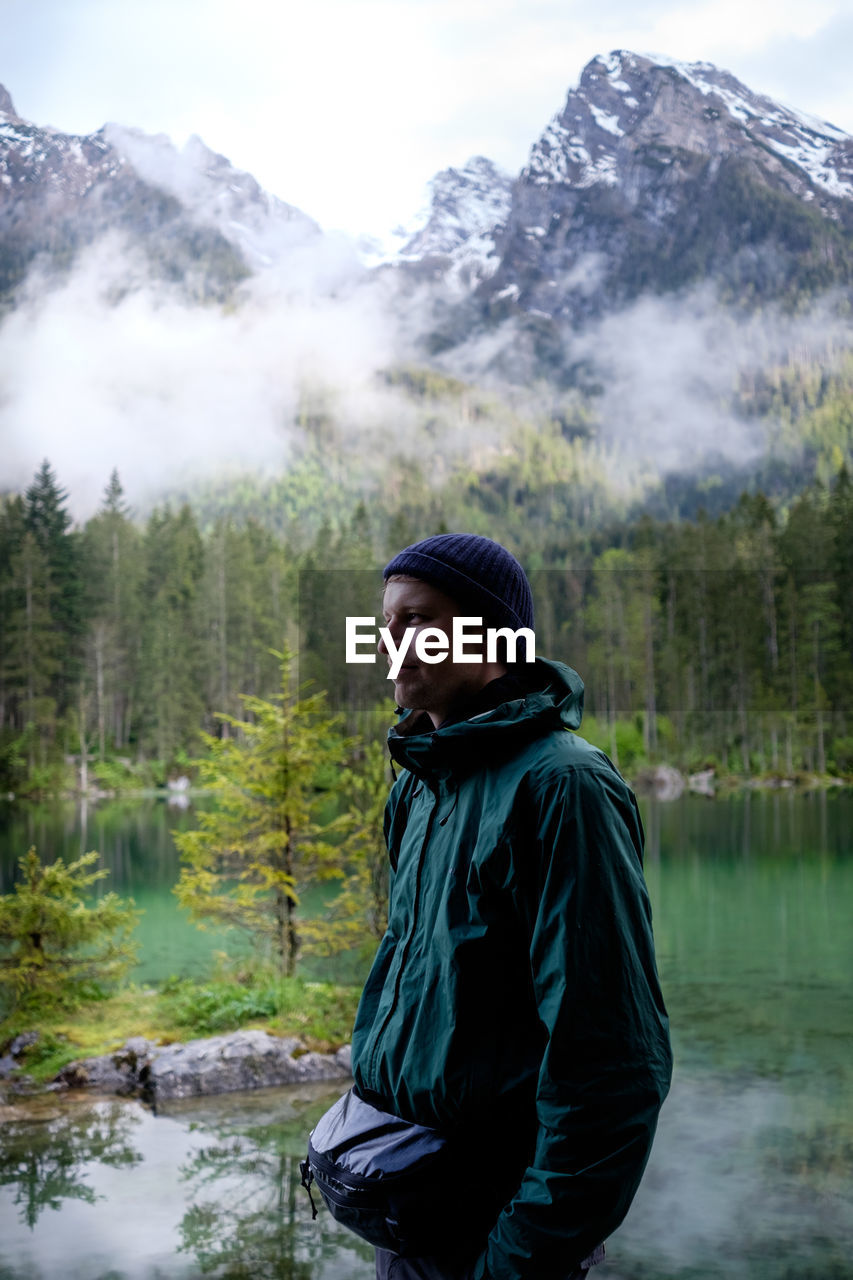 Man looking at waterfall in forest