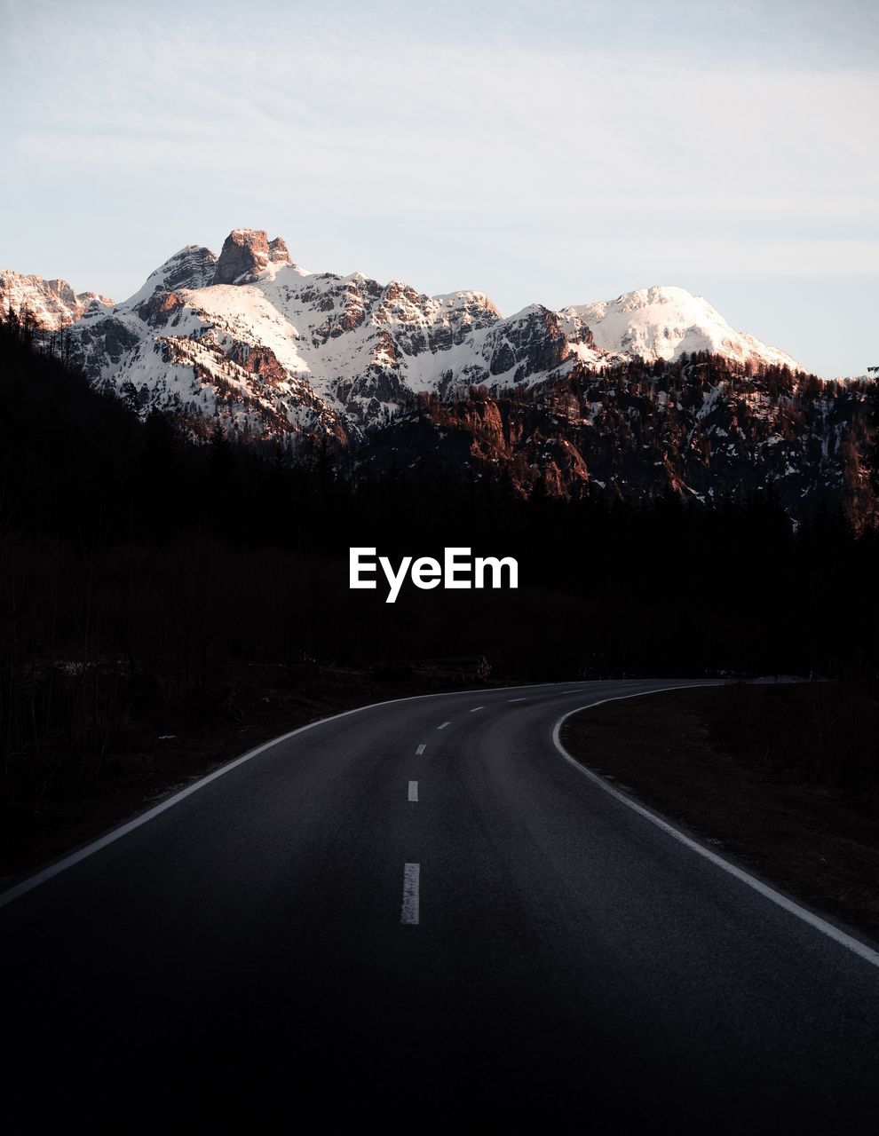 Empty road by mountains against sky