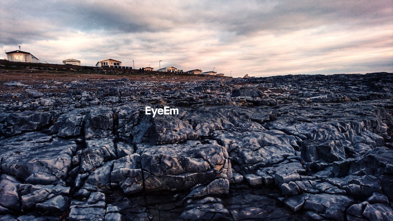 Rock formations on land against sky during sunset