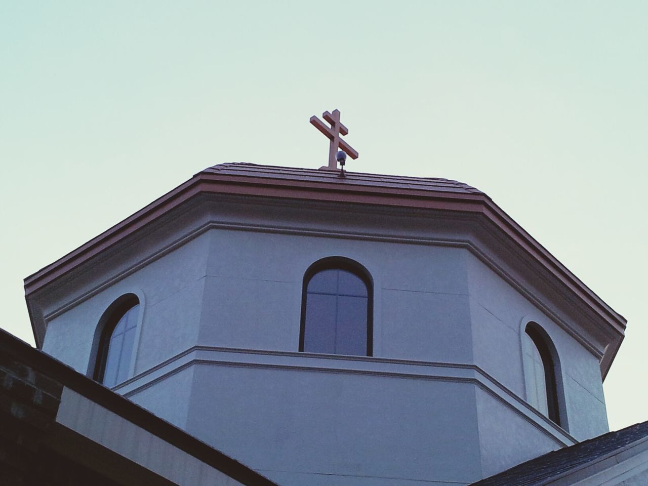 LOW ANGLE VIEW OF CROSS AGAINST BUILDING