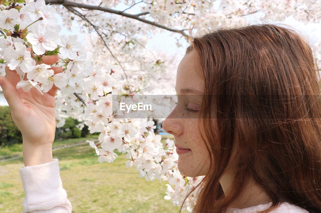Close-up of girl touching white flowers