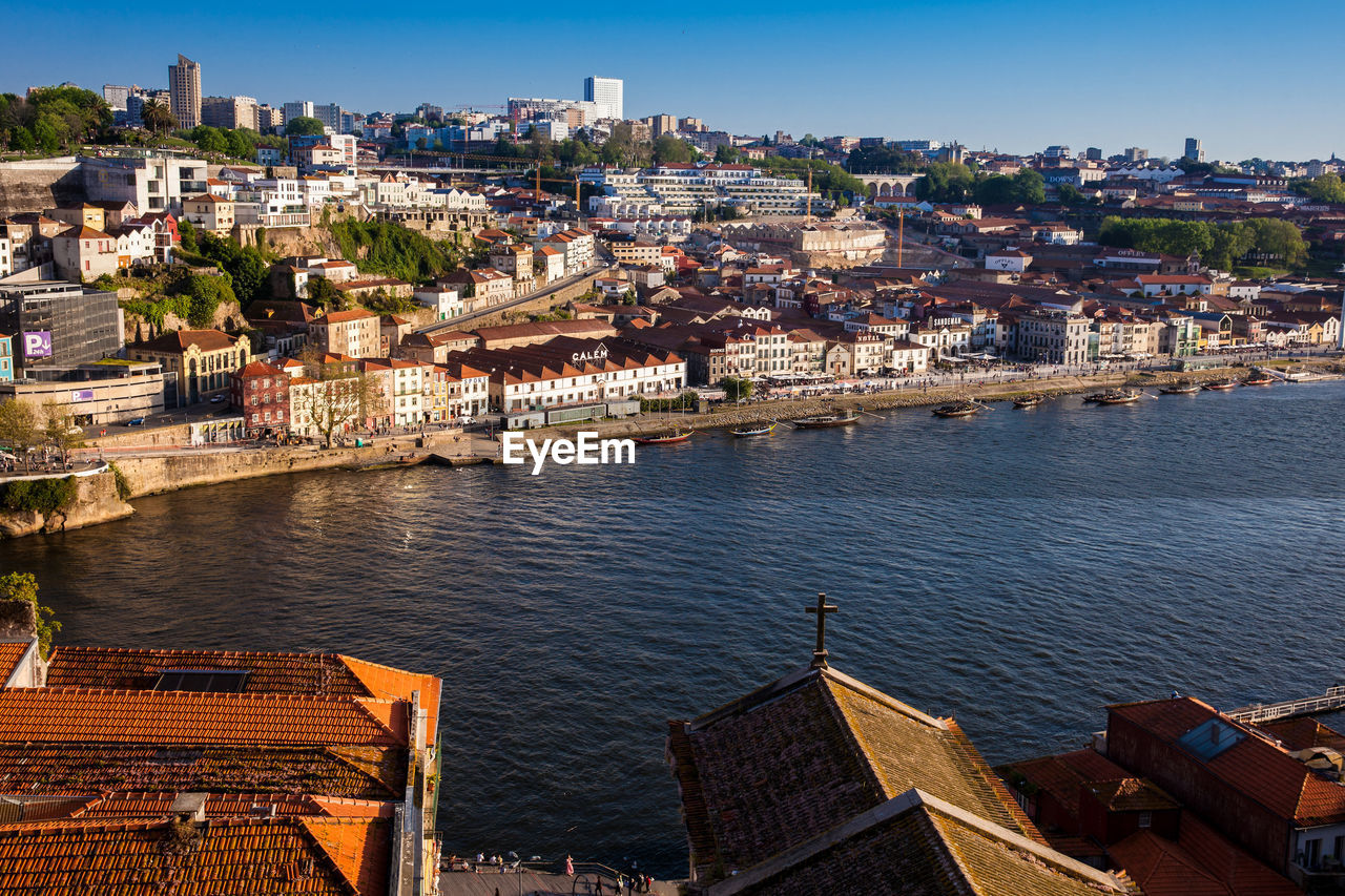 View of vila nova de gaia, traditional boats and duero river during a beautiful early spring sunset