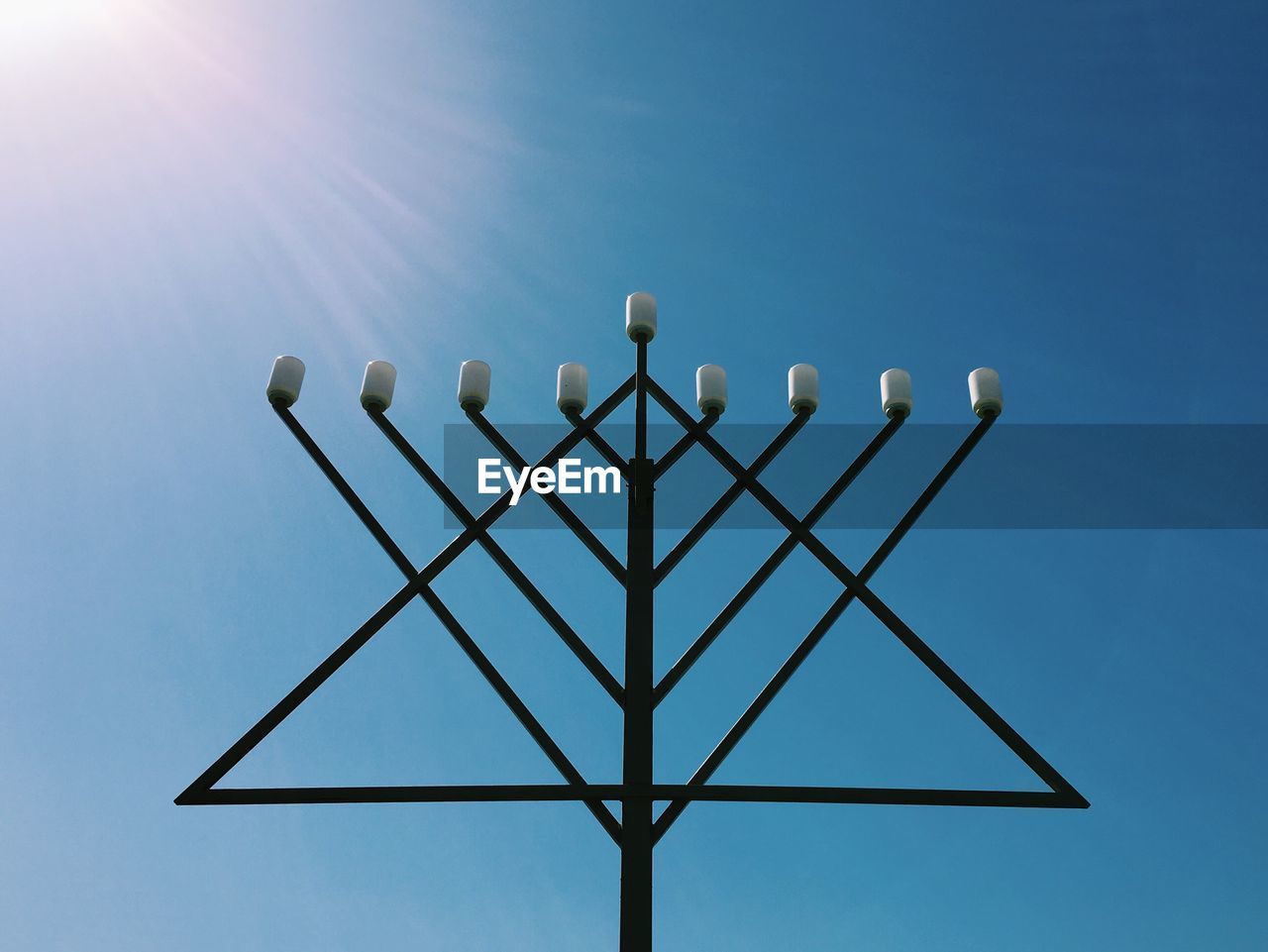 Low angle view of menorah against clear sky on sunny day