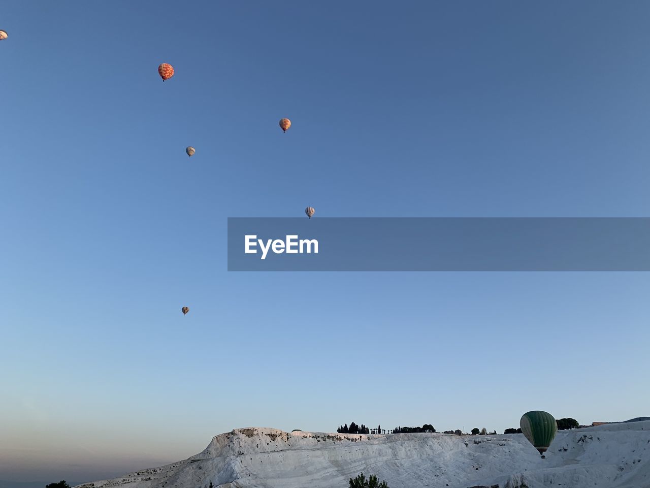 Low angle view of hot air balloons against sky in pamukkale