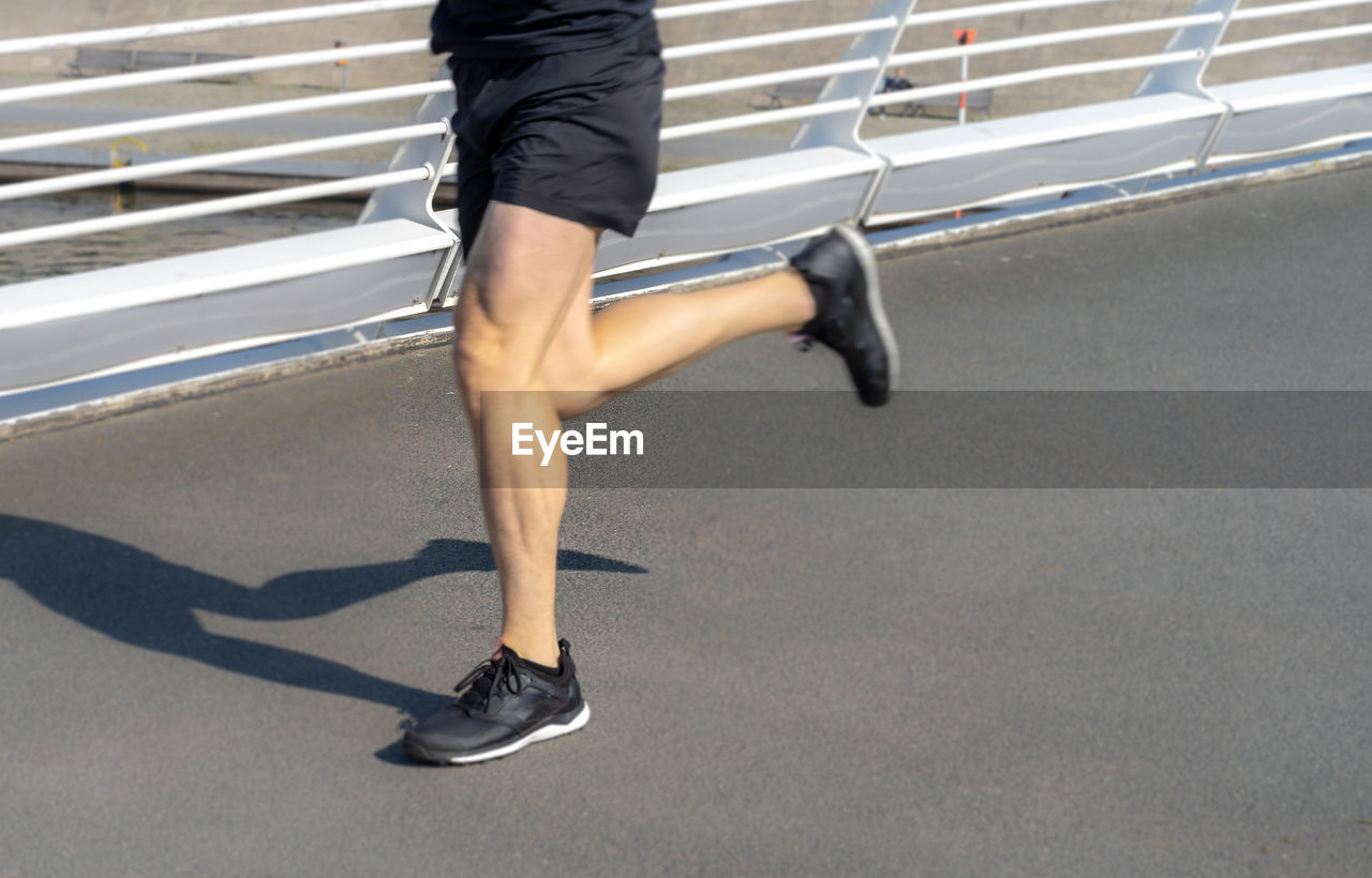 Low section of man running on road