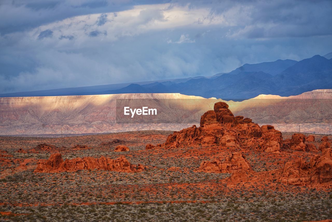 Rock formations on landscape against cloudy sky