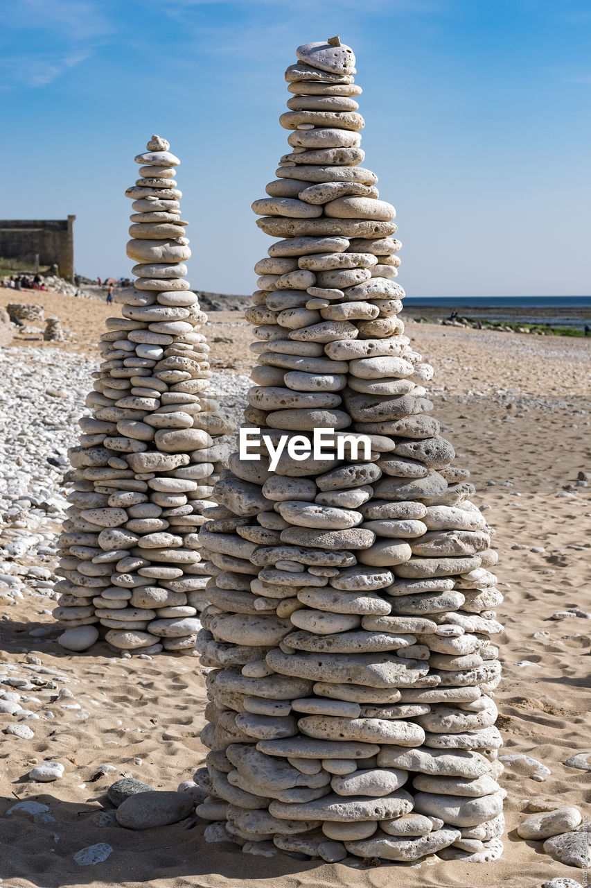 STACK OF STONE ON BEACH AGAINST SKY