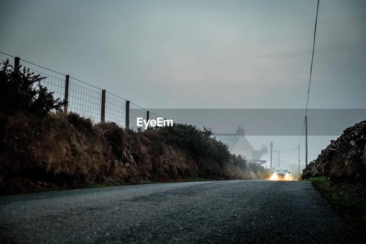 Surface level of road against sky during sunset