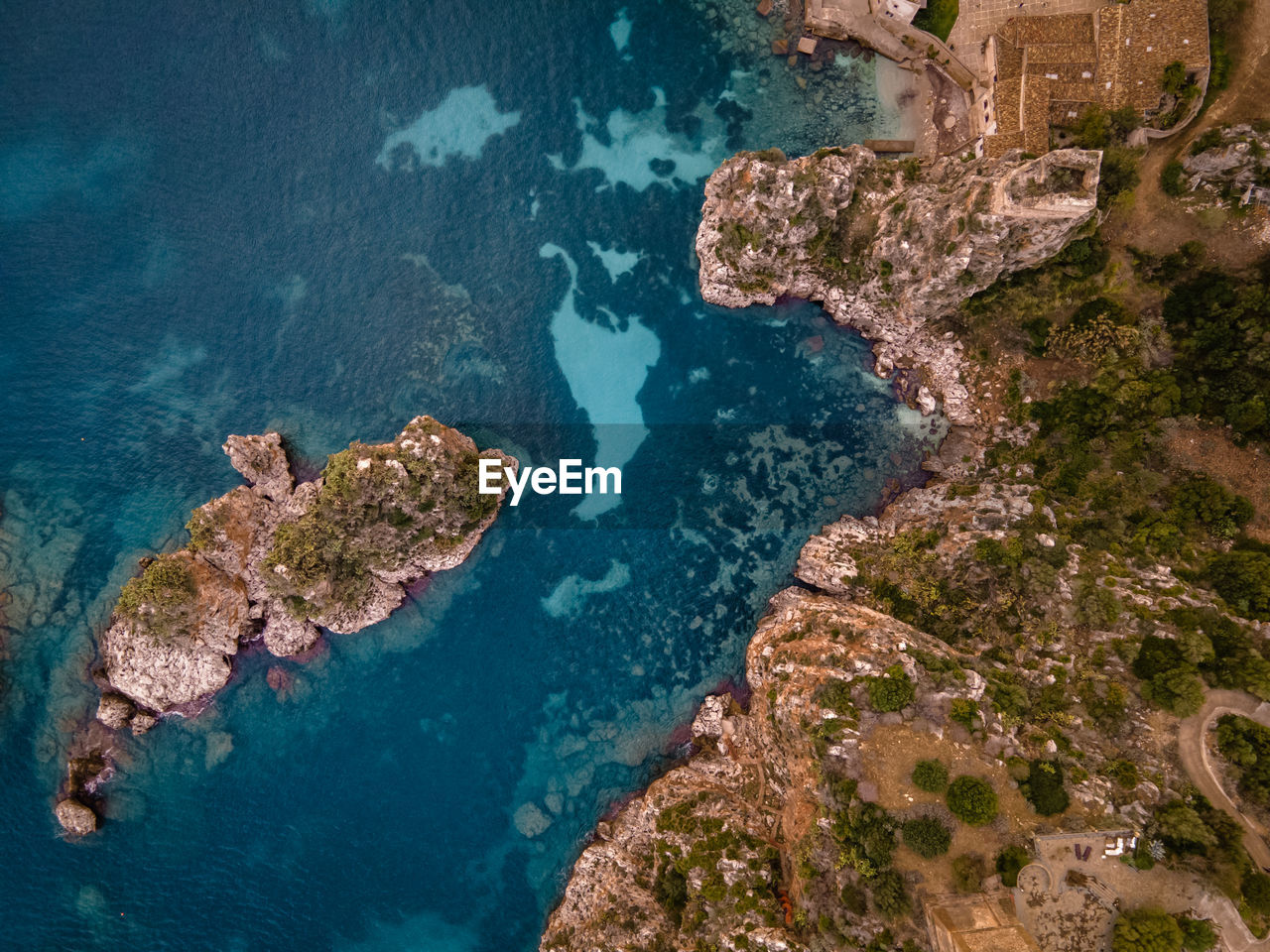 HIGH ANGLE VIEW OF ROCK FORMATIONS AT SEA