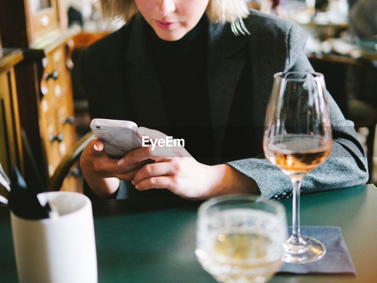 Midsection of woman using phone in restaurant