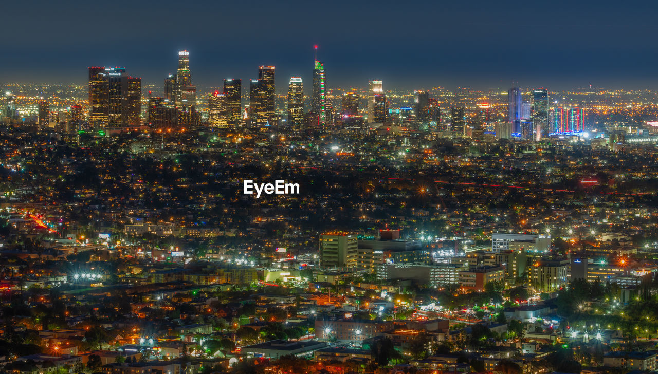 Illuminated cityscape against sky at night