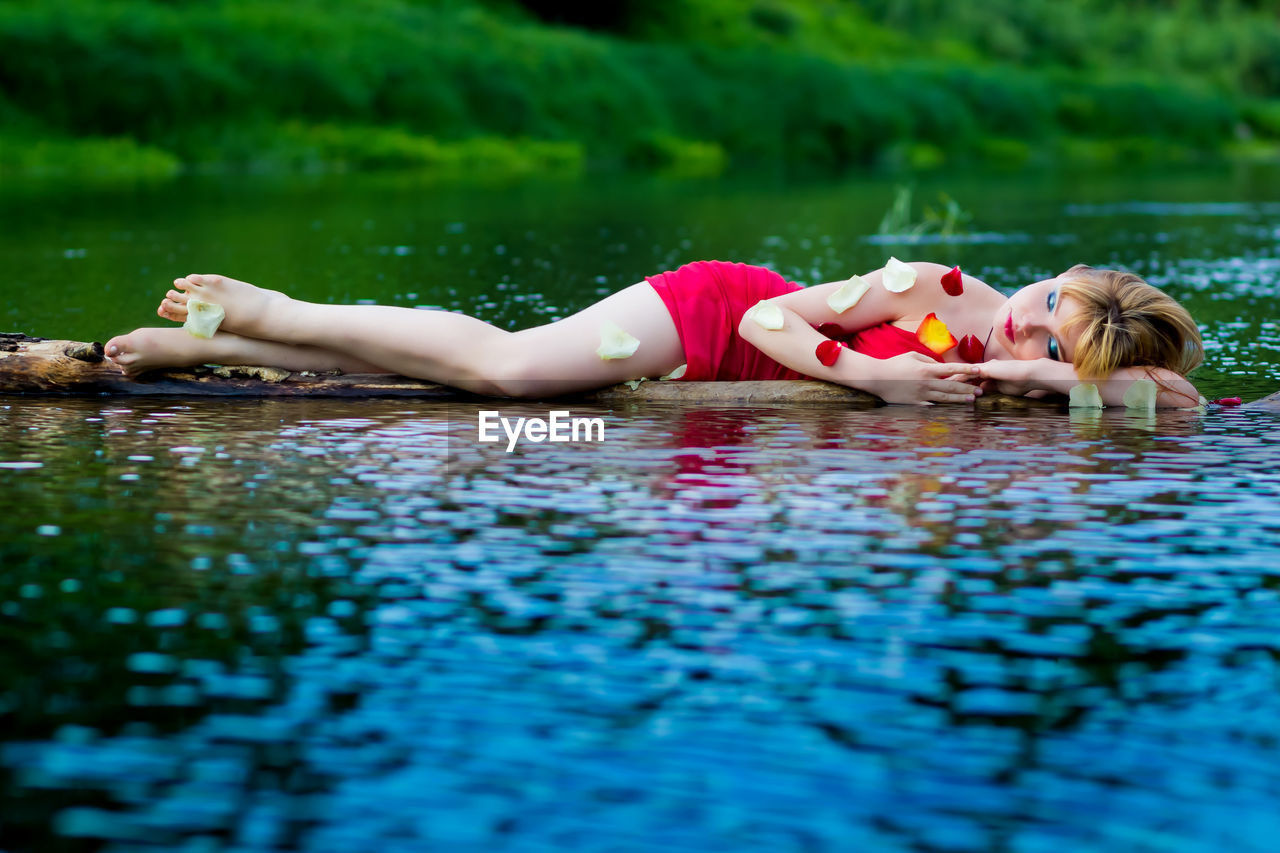Young woman sleeping in river 