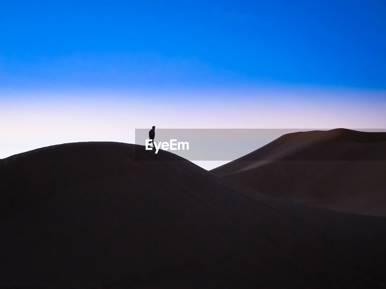 SILHOUETTE PERSON ON DESERT AGAINST SKY