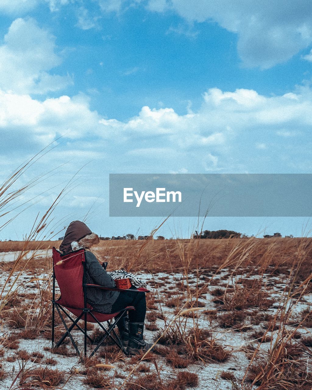 Woman on folding chair on landscape in winter