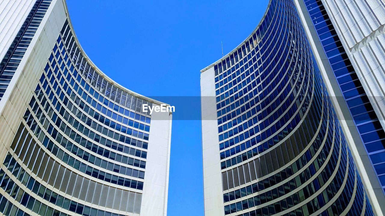 Low angle view of modern building against clear blue sky