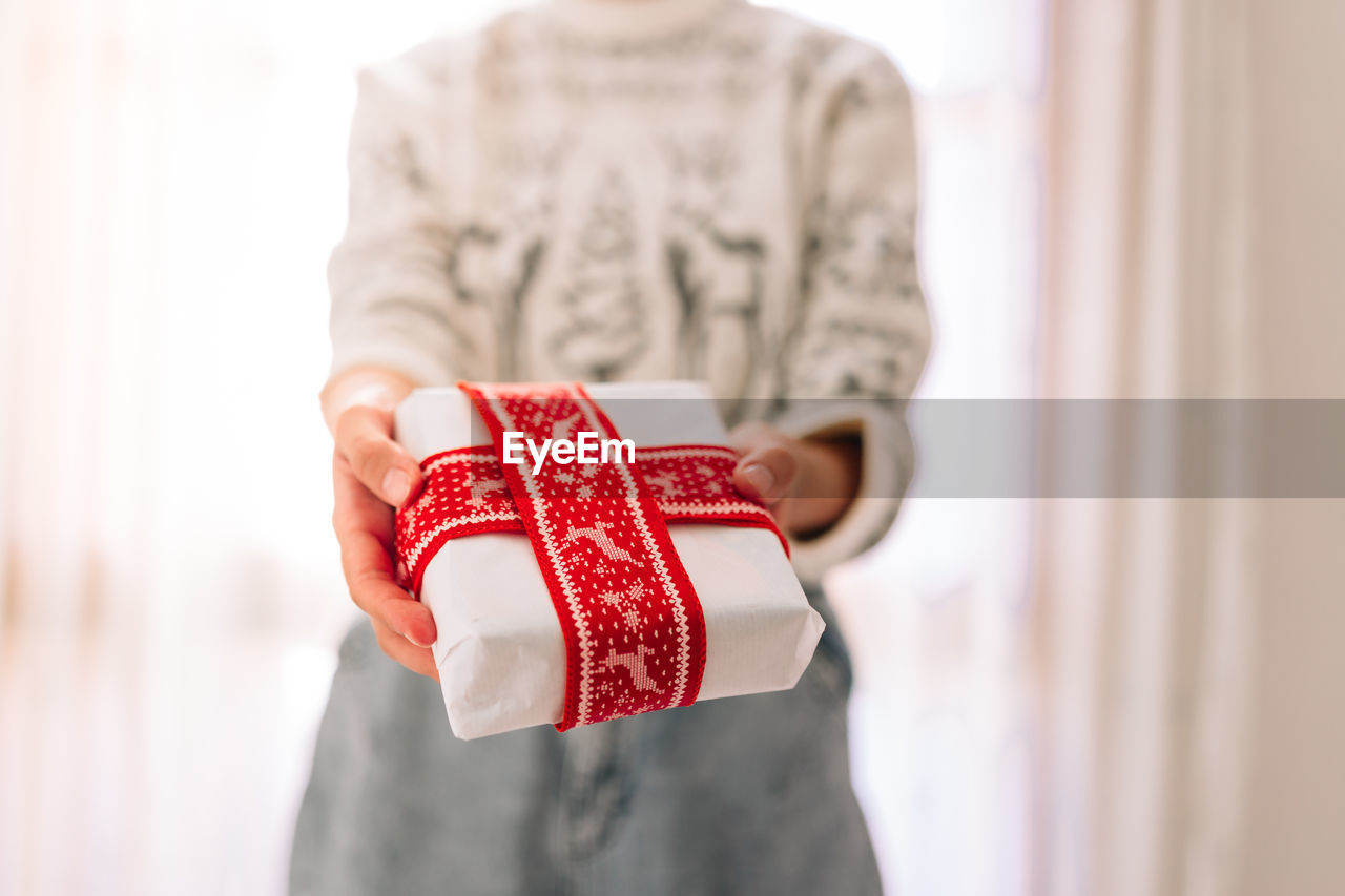 Midsection of woman holding christmas present