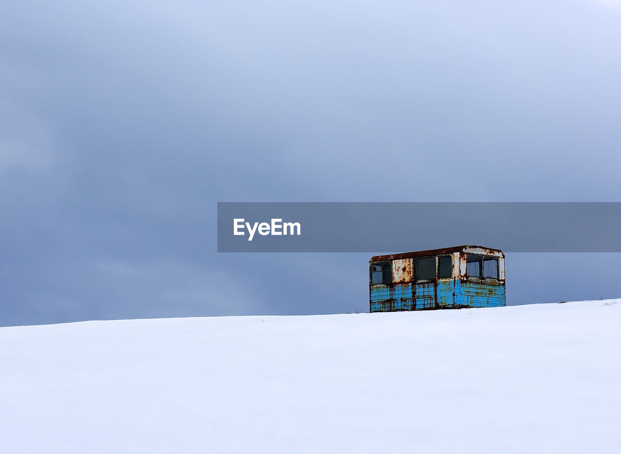 Abandoned vehicle on snow covered landscape