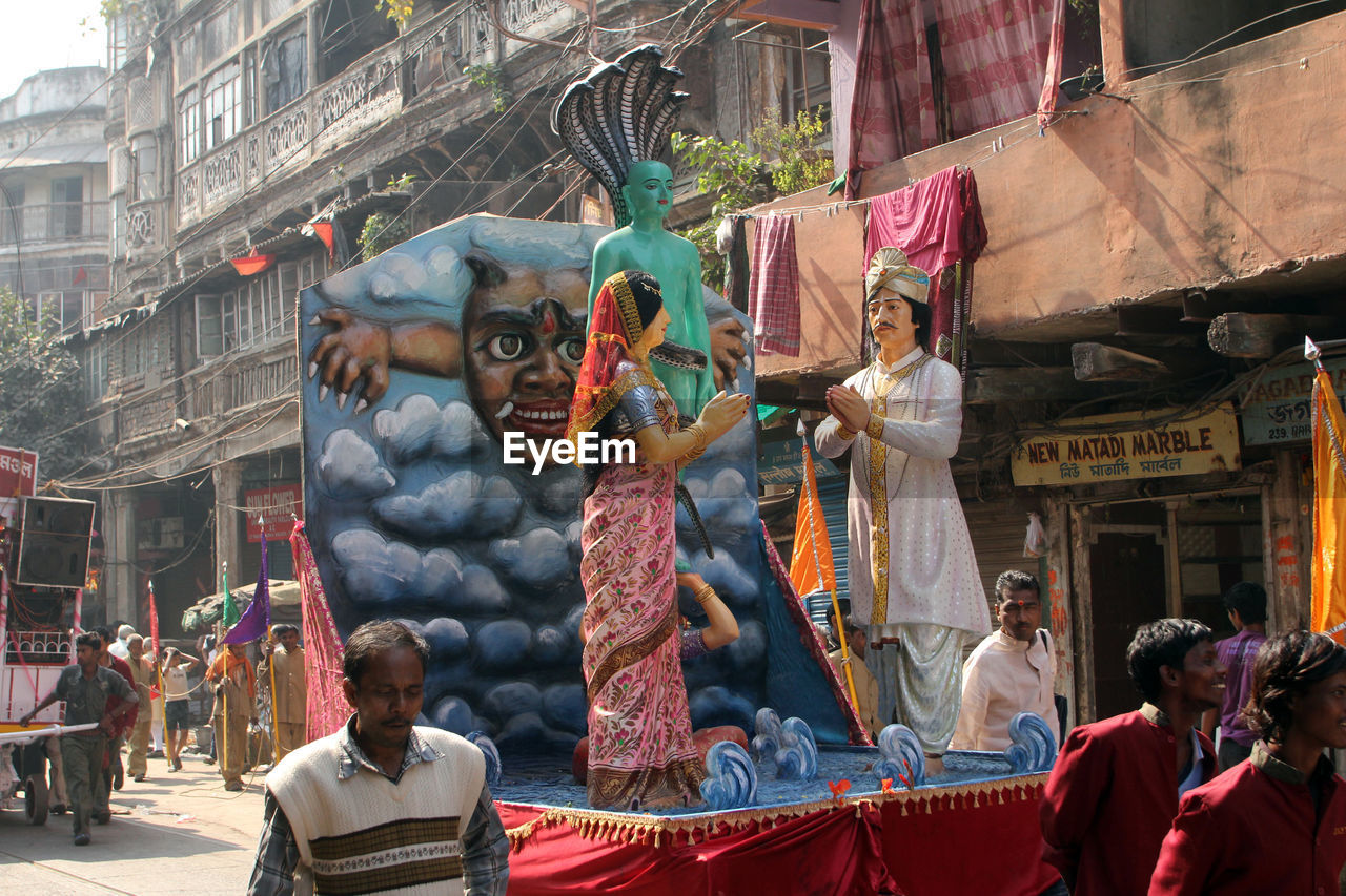 Male and female sculptures on cart at street during festival