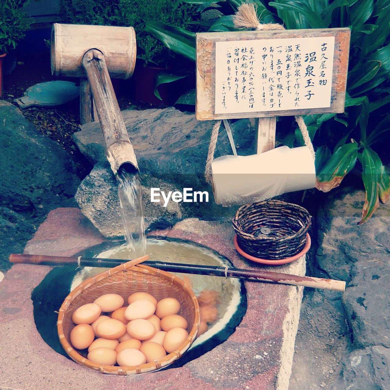 Close-up of water running into basket of eggs