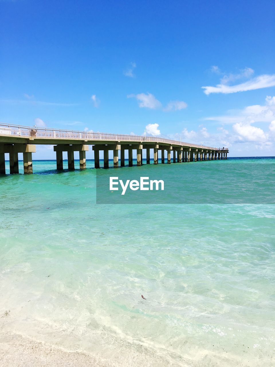 Pier over sea against blue sky