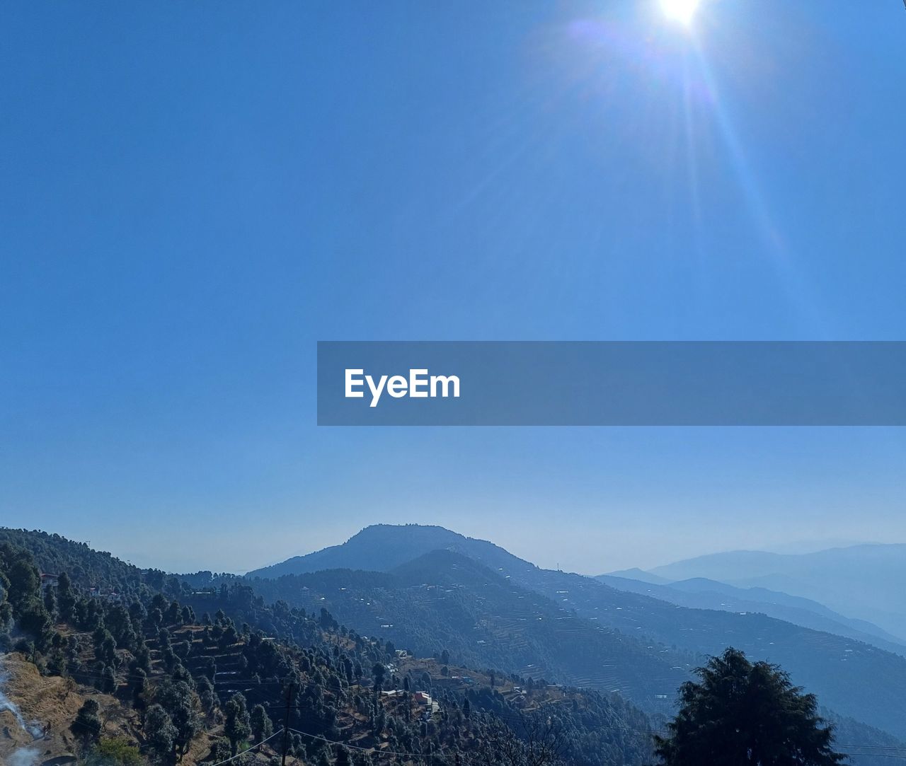 sky, mountain, scenics - nature, beauty in nature, environment, nature, tree, blue, landscape, sun, sunlight, mountain range, tranquility, sunbeam, plant, tranquil scene, no people, lens flare, clear sky, land, forest, sunny, non-urban scene, horizon, outdoors, cloud, idyllic, day, pine tree, coniferous tree, travel destinations, pinaceae, travel, morning, winter, copy space