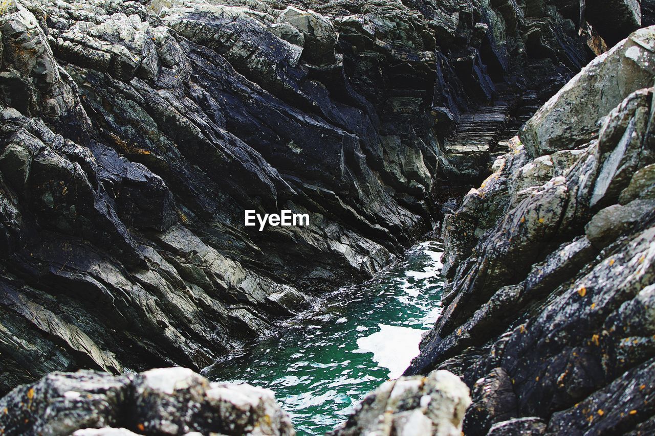 LOW ANGLE VIEW OF ROCK FORMATION IN WATER