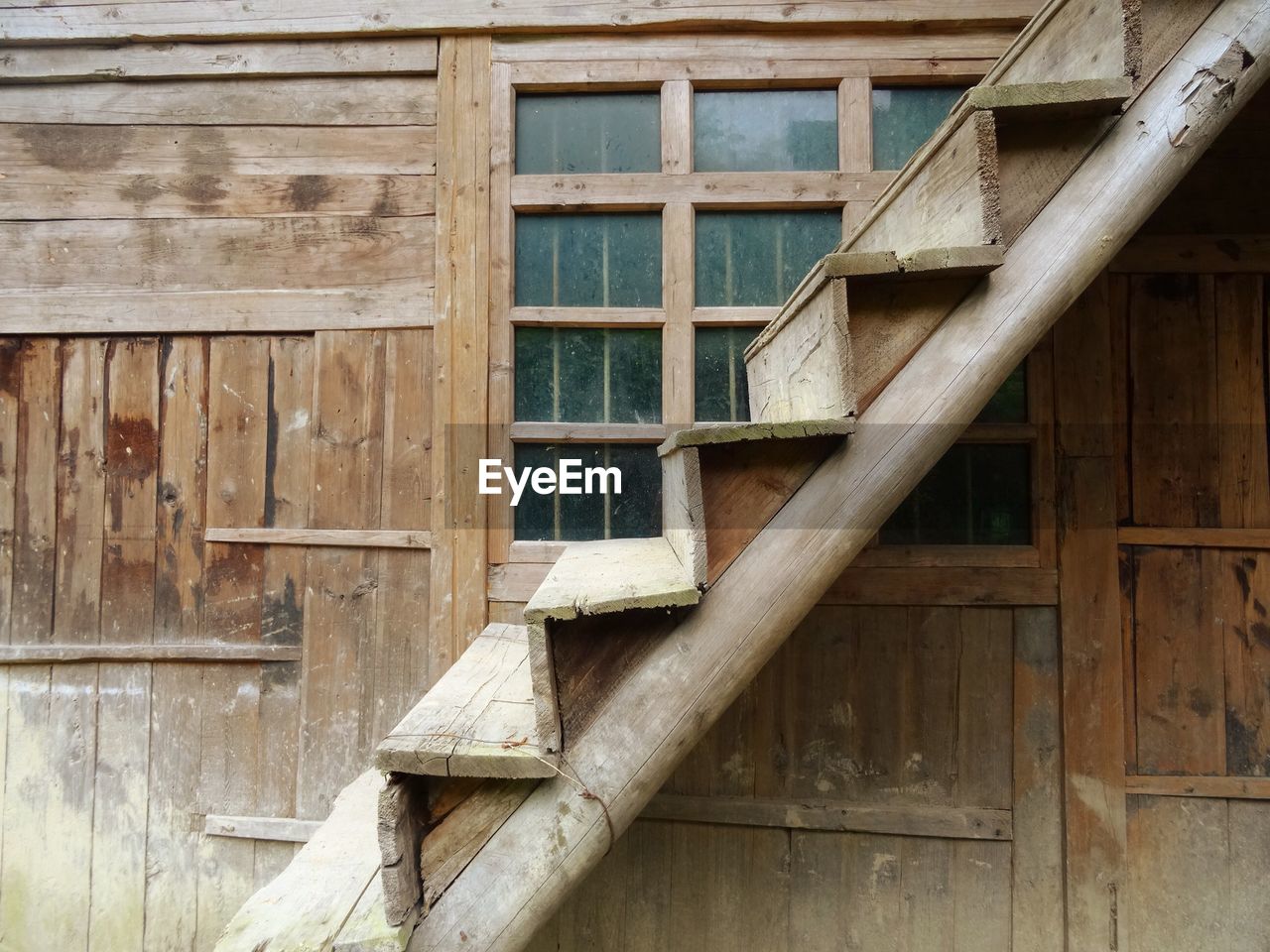 Wooden staircase against window of building