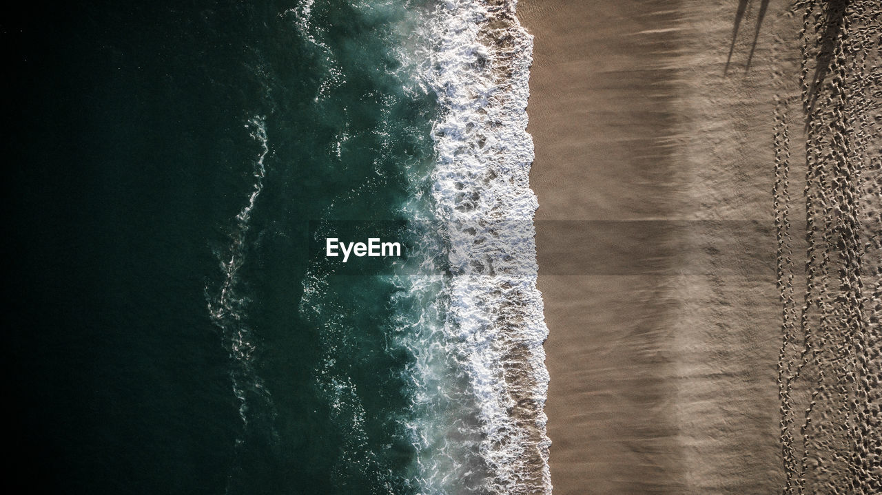 Aerial view of sea waves rushing at beach