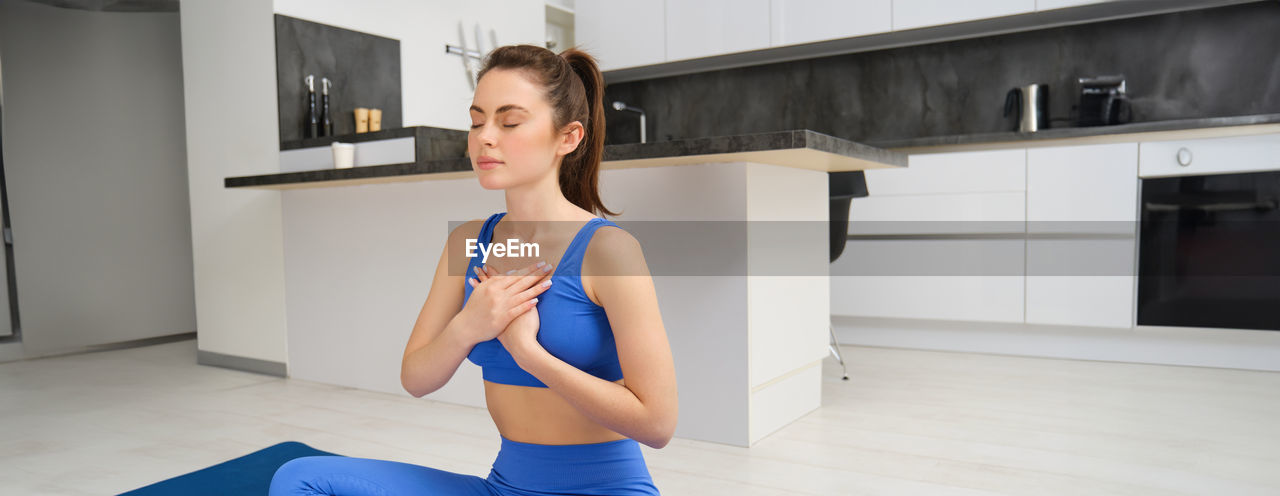 portrait of young woman exercising at home